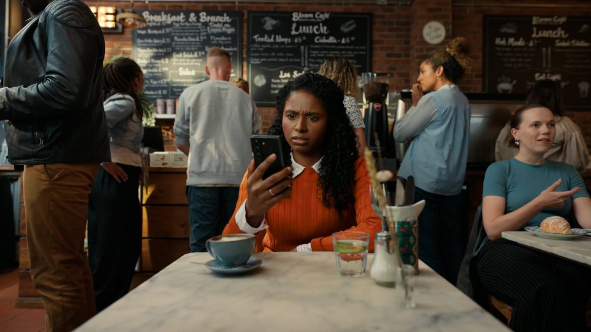 Samsung - women starting at his phone in a busy cafe