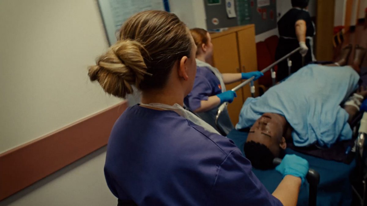 University of South Wales - A nurse pushes a patient on a trolley